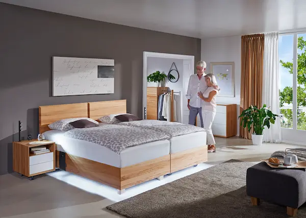Kirchner Boxlike Duobett mit Paar im Schlafzimmer, demonstriert die Höhenverstellung